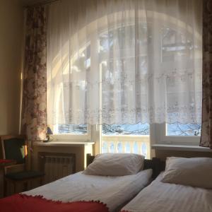 1 dormitorio con 2 camas y una ventana con cortinas en Willa Wiktoria, en Zakopane