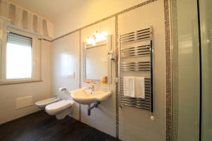a bathroom with a sink and a toilet and a mirror at B&B Al Picchio in Monopoli