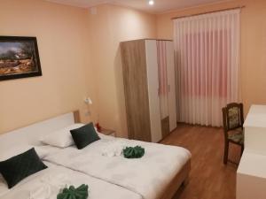 um quarto com uma cama com duas plantas verdes em Apartman Fachin em Motovun