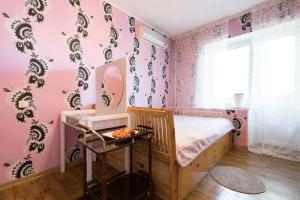 a bedroom with pink walls and a bed with a mirror at Guest House on Kaldaiakova 38 in Almaty