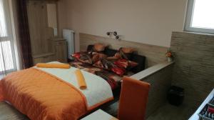 a bedroom with a bed with an orange comforter at Kéri Vendégház in Mosonmagyaróvár