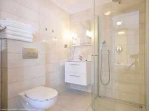 biała łazienka z prysznicem i toaletą w obiekcie Polli Apartamenty w Pogorzelicy