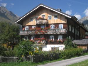 a large wooden house with flowers in front of it at Haus Ursula in Kals am Großglockner