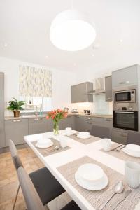 a kitchen with a table with plates and flowers on it at Crown Apartment in Inverness