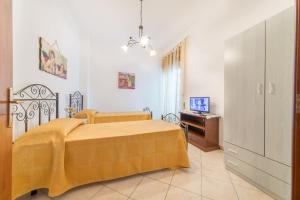 a bedroom with a yellow bed and a television at Salento Sweet Home in Melissano