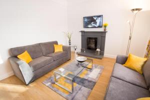 a living room with two couches and a fireplace at Crown Apartment in Inverness