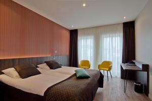 A bed or beds in a room at Hotel Roermond