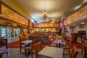 a restaurant with tables and chairs and a chandelier at Berkshire Mountain Lodge in Pittsfield