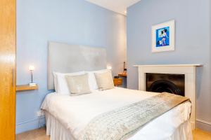a bedroom with a large white bed with a fireplace at Brightonwave in Brighton & Hove