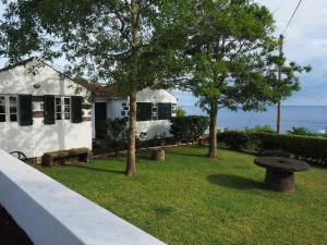 a white house with trees in front of it at Monserrate - Galera Cottage in Caloura