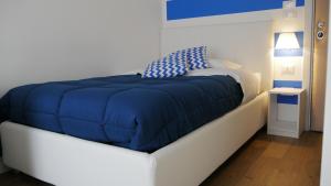 a bed with a blue blanket on top of it at Domus Nova in Reggio di Calabria