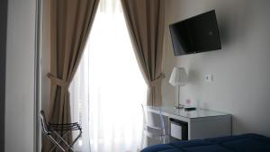 sala de estar con ventana grande y TV en Domus Nova en Reggio Calabria