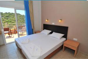 a bedroom with a large bed and a balcony at Thalassorama Studios in Skala Marion