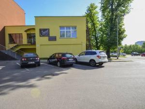 tres autos estacionados en un estacionamiento frente a un edificio en Noclegi Mikołów, en Mikołów