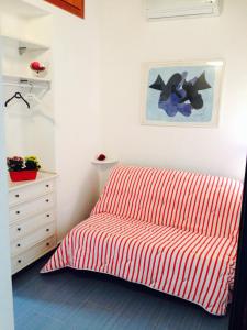 un dormitorio con una cama a rayas rojas y blancas y una cómoda en Villa Aurora, en Chia 13 fotos más