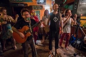 a group of people standing in a room with a guitar at La Iguana Perdida in Santa Cruz La Laguna