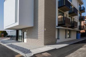 a building with a sidewalk next to a street at MaisonMe Boutique Hotel in Bardolino