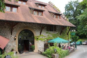 a building with a green umbrella in front of it at WASSERSTELZ Historisches Genusshotel & Restaurant am Rhein in Hohentengen