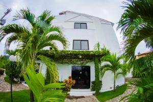 ジャクマにあるSereia do Mar Pousada Carapibusのヤシの木が目の前に広がる白い家