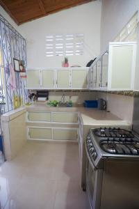 La cuisine est équipée de placards blancs et d'un four avec plaques de cuisson. dans l'établissement Apartamento amoblado, à Quibdó