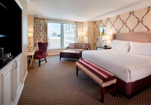 una camera d'albergo con un grande letto e un divano di Caesars New Orleans a New Orleans