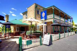 a restaurant with tables and umbrellas in front of a building at The Richmond Arms Hotel in Richmond
