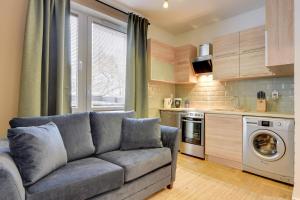 a living room with a couch and a kitchen at Lion Apartments MEWA in Sopot