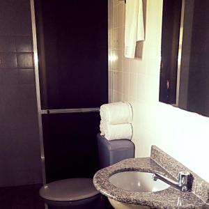 un bagno con lavandino, WC e specchio di Hotel Fazenda Menino da Porteira a Ouro Fino Altre 52 foto