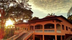 una grande casa arancione con portico e scale di Hotel Fazenda Menino da Porteira a Ouro Fino