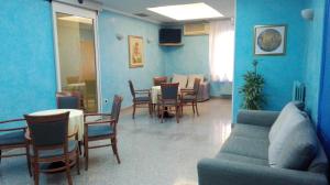 sala de estar con paredes azules, mesa y sillas en Hotel Mario, en San Benedetto del Tronto