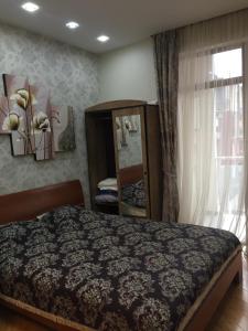 1 dormitorio con cama, espejo y ventana en Apartment on Parnavaz Mepe Street, en Batumi