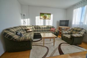 Una sala de estar con dos sofás y un televisor. en Fecske Vendégház, en Hévíz