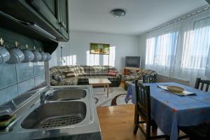 Una cocina con fregadero y una sala de estar. en Fecske Vendégház, en Hévíz 22 fotos más
