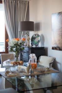 a glass table with a lamp and flowers on it at B & B La Terrazza sul mare in Portoferraio