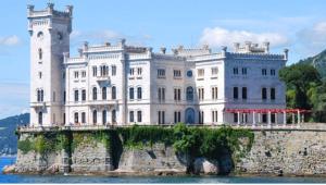 ein großes weißes Schloss auf einem Felsen im Wasser in der Unterkunft Casa vacanza Tigor in Triest