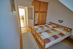 ヘーヴィーズにあるFecske Vendégházのベッドルーム1室(ベッド1台付)、木製キャビネットが備わります。