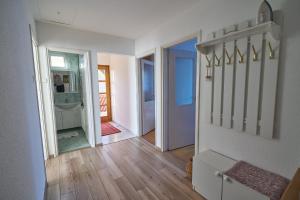 a room with a hallway with a door and wooden floors at Fecske Vendégház in Hévíz
