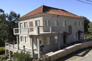 ein Haus mit einem Balkon an der Seite in der Unterkunft Casa do Campinho in Fundoais