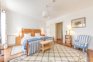 a bedroom with a bed and two blue chairs at Casa da Ria - Turismo Rural in Ílhavo