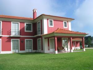 una gran casa roja con un patio verde en Casa da Ria - Turismo Rural, en Ílhavo