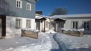 a yard covered in snow next to a house at Ferienwohnungen Mühlenhof Oberseifersdorf in Mittelherwigsdorf