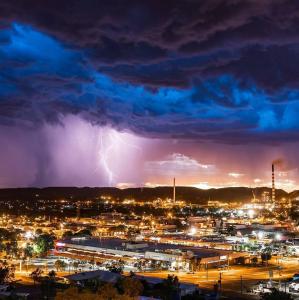 a lightning storm over a city at night at Accommodation @ Isa in Mount Isa