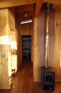 a room with a woodburning stove in a building at Cabañas Ranco Lauken in Lago Ranco