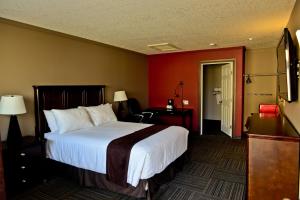 121 Steakhouse & Motel في Assiniboia: غرفة الفندق بسرير كبير ومكتب