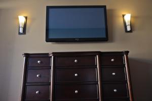a television mounted on a wall next to a lamp at 121 Steakhouse & Motel in Assiniboia