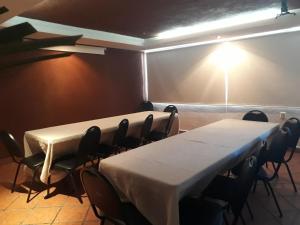 two tables in a room with chairs and a light at Hotel Sacre in San Juan Bautista Tuxtepec