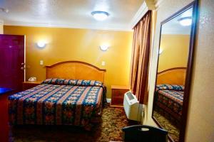 a hotel room with a bed and a mirror at Satellite Motel, Los Angeles - LAX in South Los Angeles