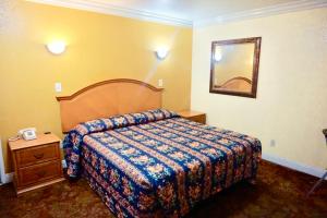 una habitación de hotel con una cama y un espejo en Satellite Motel, Los Angeles - LAX, en South Los Angeles 6 fotos más