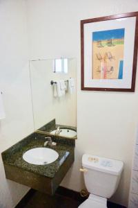 Un baño con lavabo, inodoro y espejo. en Satellite Motel, Los Angeles - LAX, en South Los Angeles
