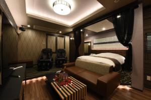 - une chambre avec un lit et un canapé dans l'établissement Hotel Star Resort Hers (Adult Only), à Sagamihara